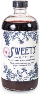 small bottle with deep purple liquid and white label with floral accents that says Sweet's syrup 